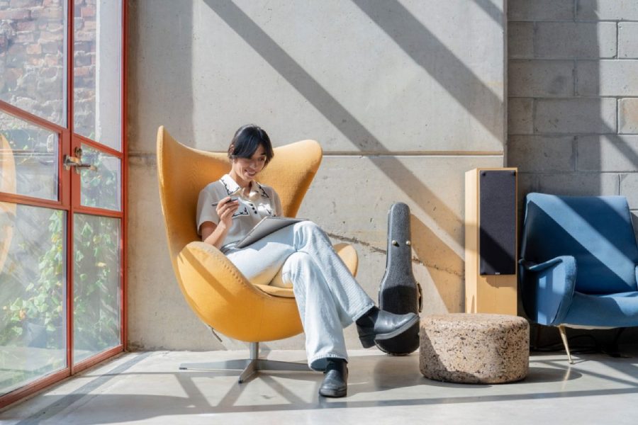 Woman sitting casually smiling, looking at tablet display