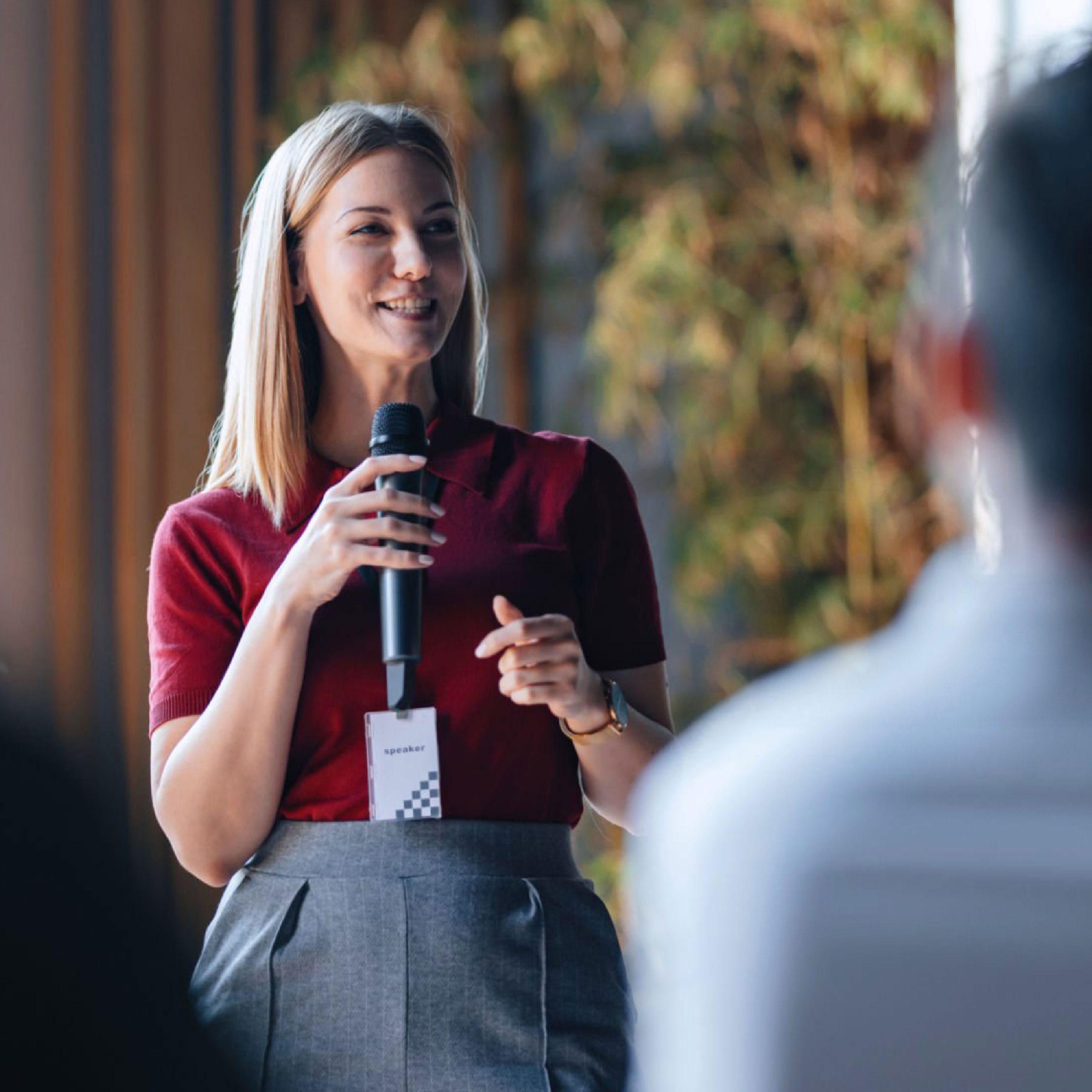 Business women presenting at a conference with a microphone
