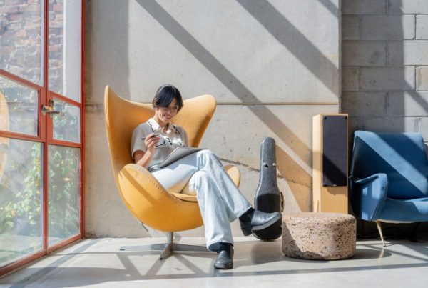 Woman sitting casually smiling, looking at tablet display